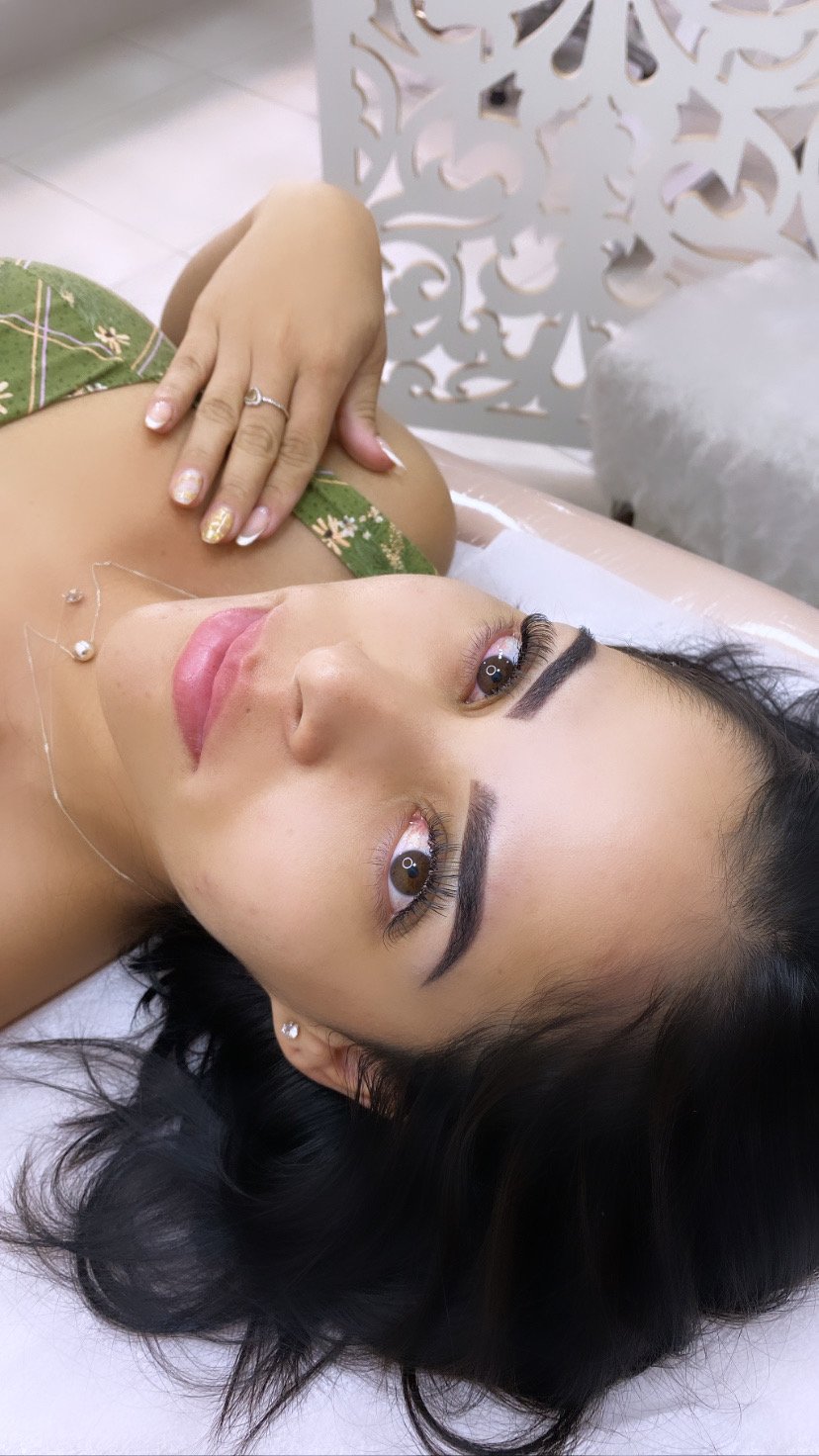 Cliente com extensão de cílios, sobrancelhas alinhadas e unhas decoradas feitas no estúdio
